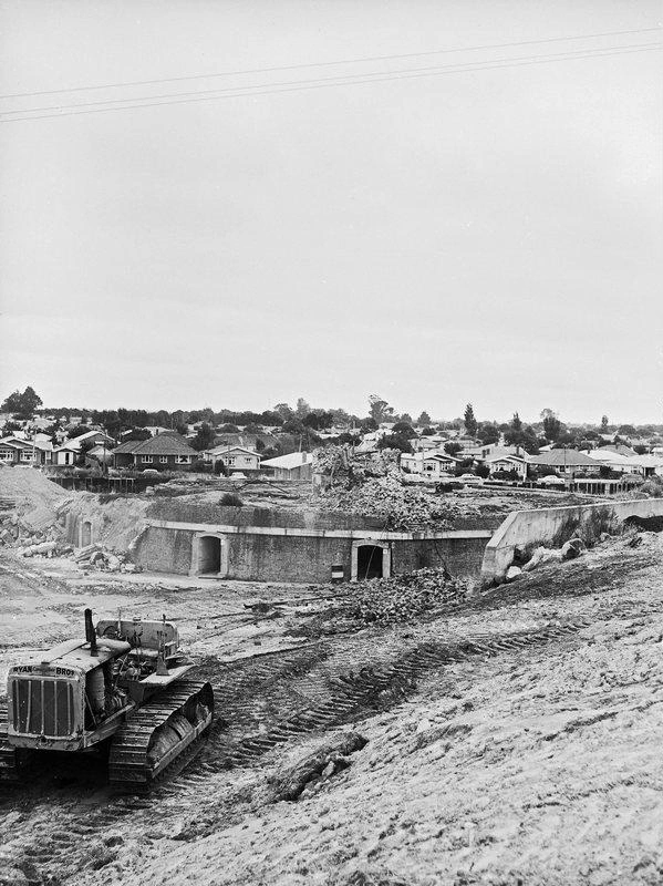 Demolition Brickworks Kilns and the Chimney has Gone. Ryan Brothers Branded on the Bulldozer Began Quick Demolitions in the Heart of Christchurch. Centaurus Road, Note the Christchurch Gas Works Gasometers at Left Rear. Christchurch, Canterbury, New Zealand.