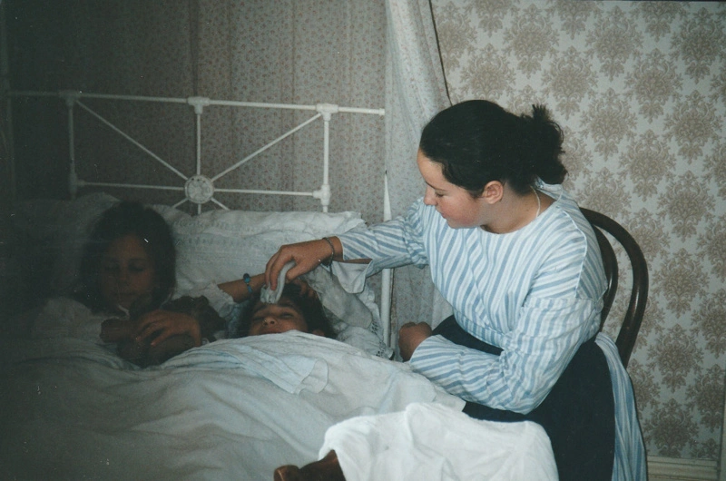 Puhinui bedroom scene during a Candle lit tour at Howick Historical Village, 27 May 2003 showing a 'mother tending her daughters in bed'.