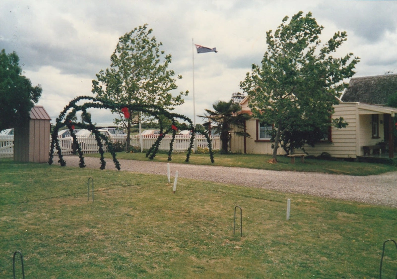 Christmas, past and present at Howick Historical Village, 12 December 1987. Greenery hoops over the road between a sentry box and Brindle Cottage.