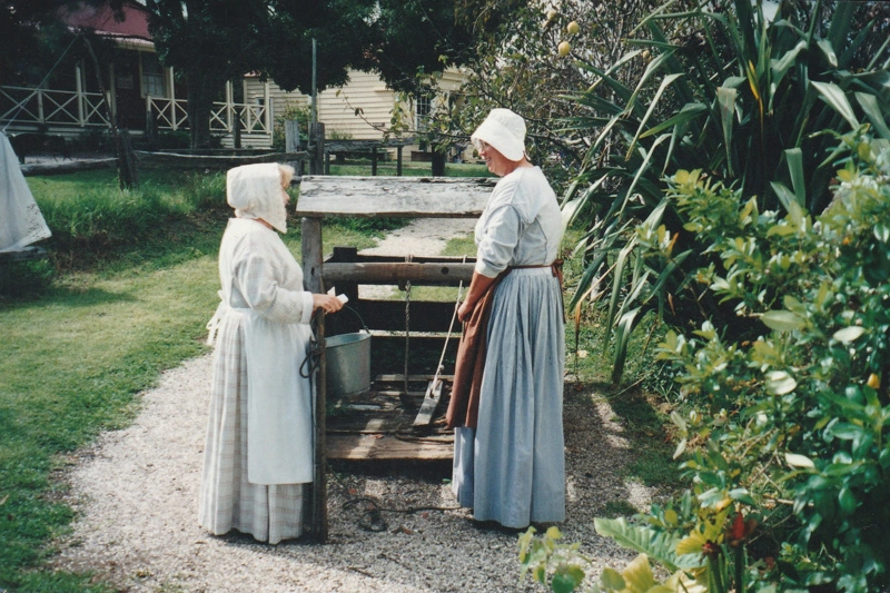 Margaret Robinson and Janet Lewis, in costume beside the well in Howick Historical Village.