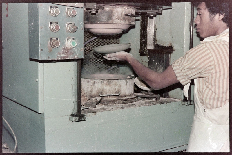 Negative - Man preparing to apply clay to a press moulding machine