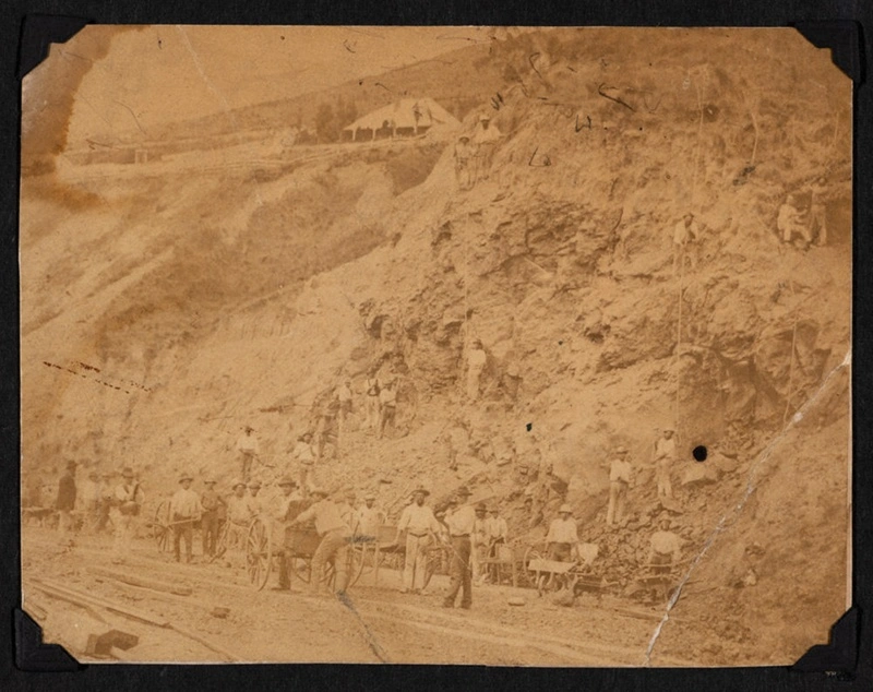 The hard labour gang from Lyttelton Prison quarrying stone from a cliff past the Gas-works, probably late 1870s.