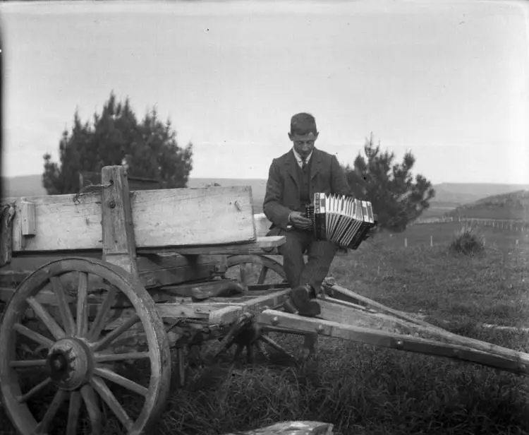 Man playing an accordion at Strathmore, 1910