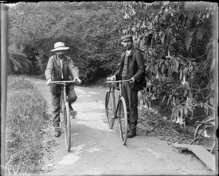 Two men with bicycles at The Avenue, Karangahape Road, 1905