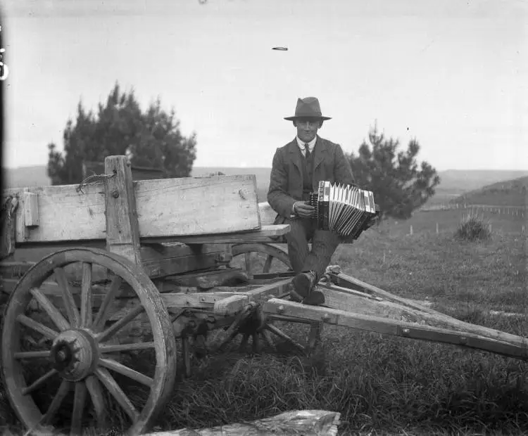 Man playing an accordion at Strathmore, 1910