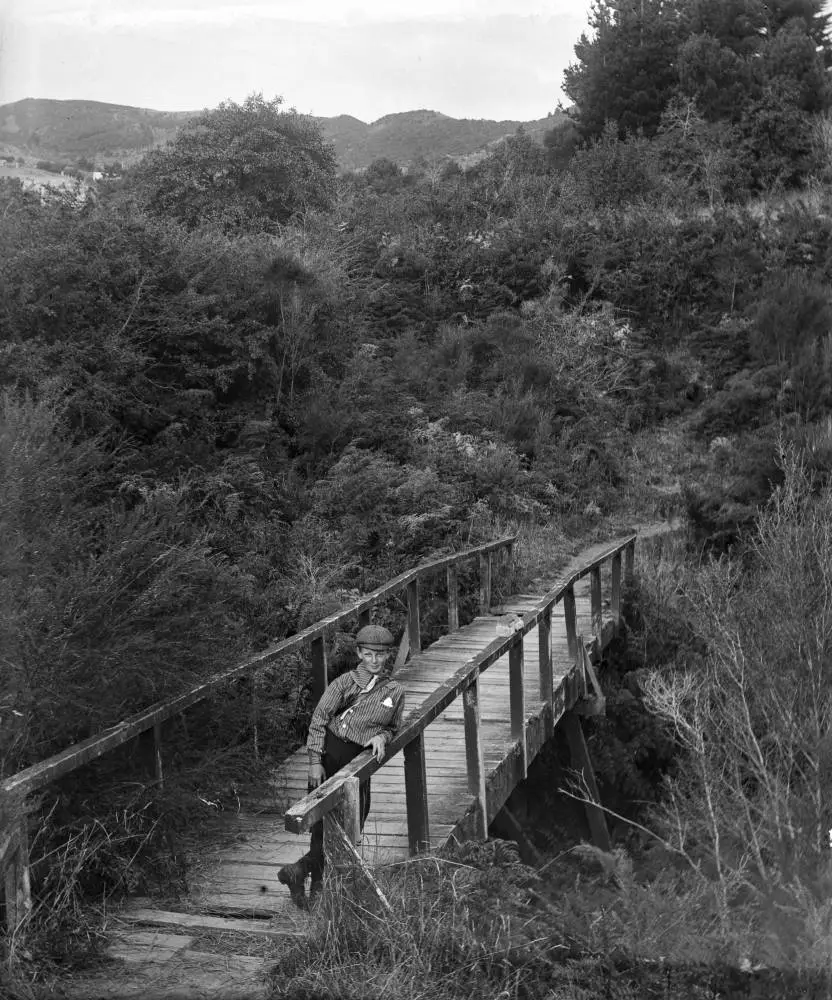 Boy standing on a wooden bridge, 1906