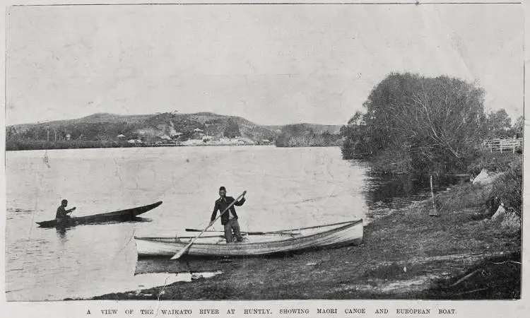 A view of the Waikato River at Huntly with a Maori canoe and a European boat