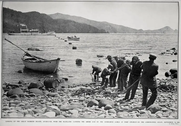 LINKING UP THE GREAT BARRIER ISLAND, AUCKLAND, WITH THE MAINLAND: LANDING THE SHORE END OF THE SUBMARINE CABLE AT PORT CHARLES ON THE COROMANDEL COAST, SEPTEMBER 26, 1908