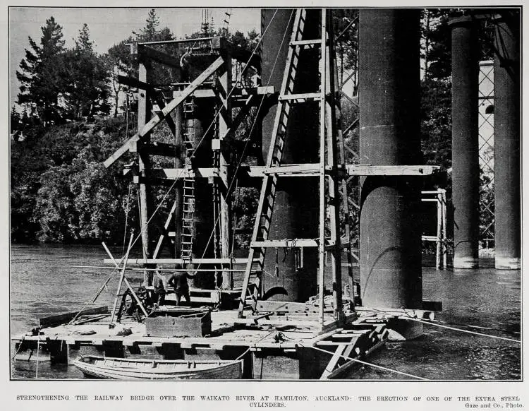 STRENGTHENING THE RAILWAY BRIDGE OVER THE WAIKATO RIVER AT HAMILTON, AUCKLAND: THE ERECTION OF ONE OF THE EXTRA STEEL CYLINDERS