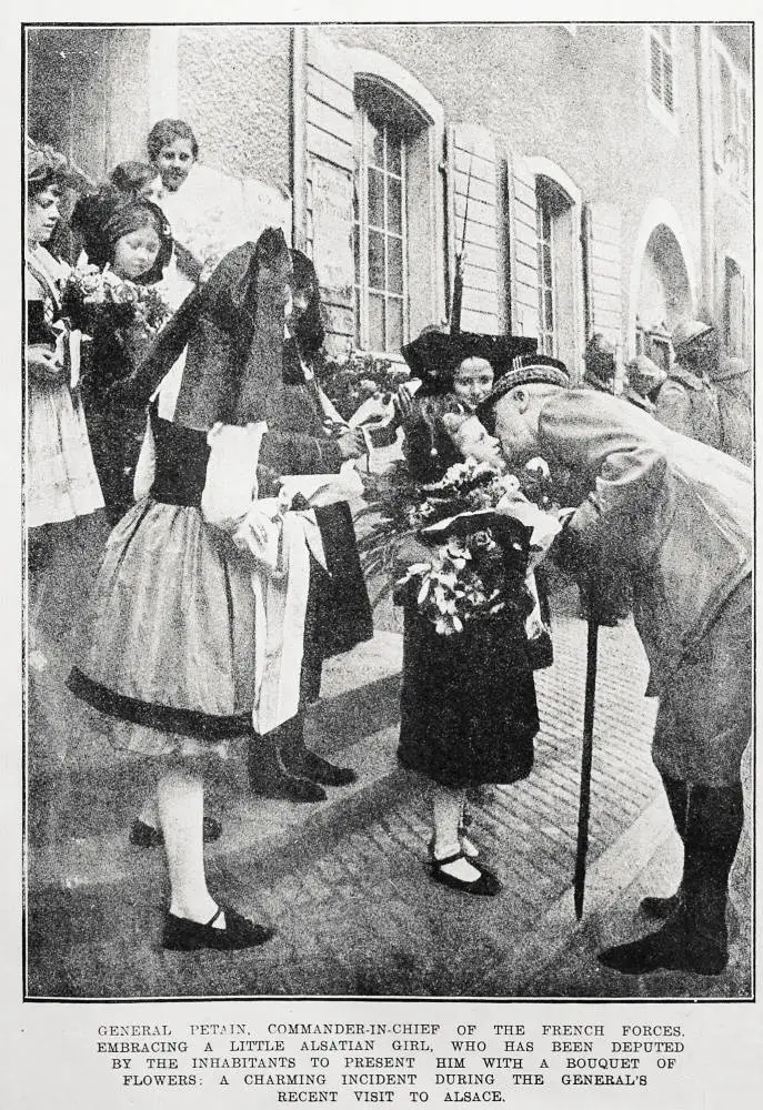 General Petain, Commander-in-Chief of the French forces. Embracing a little Alsatian girl, who has been deputed by the inhabitants to present him with a bouquet of flowers: a charming incident during the general's recent visit to Alsace