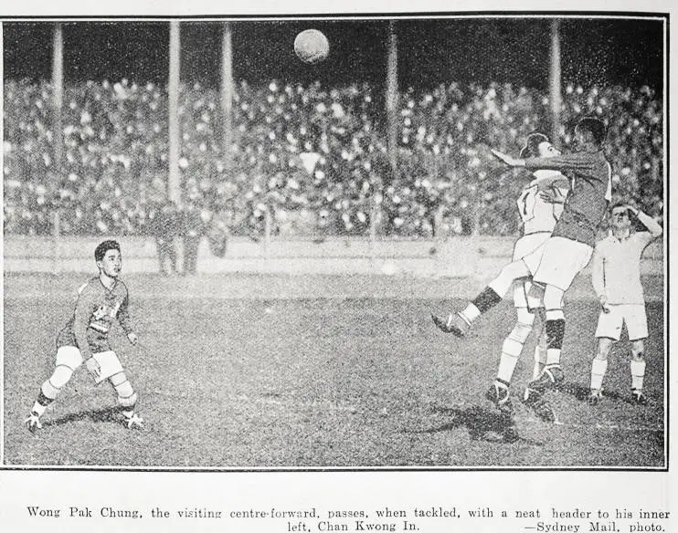 Wong Pak Chung, the visiting centre-forward passes, when tackled, with a neat header to his inner left, Chan Kwong In