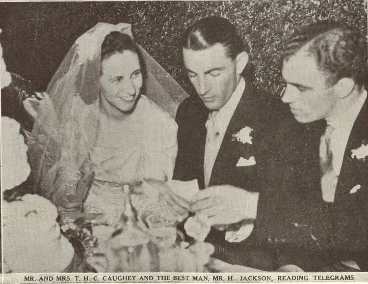 Mr. and Mrs. T. H. C. Caughey and the best man, Mr. H. Jackson, reading telegrams