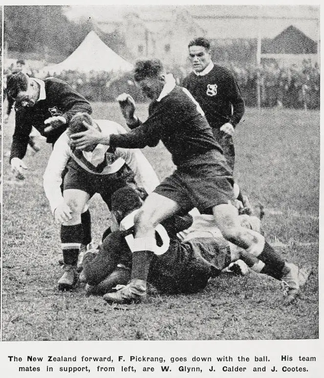 The New Zealand forward, F. Pickrang, goes down with the ball. His team mates in support, from left, are W. Glynn, J. Calder and J. Cootes