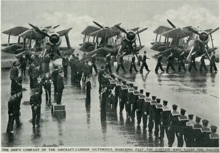 The ship's company of the aircraft-carrier Victorious marching past the captain who takes the salute