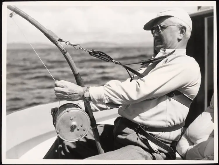 A man playing a striped marlin on board the launch 'Ozone'