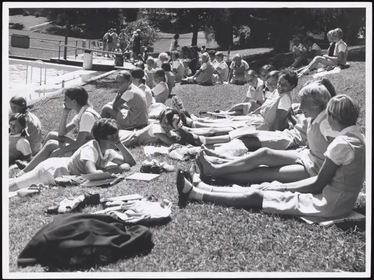 Students beside an outdoor swimming pool, Hamilton
