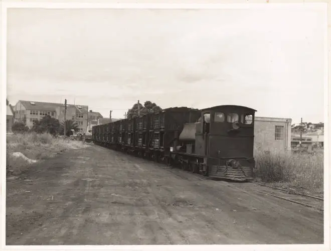 Steam engine shunts empty livestock wagons away from Westfield Freezing Works