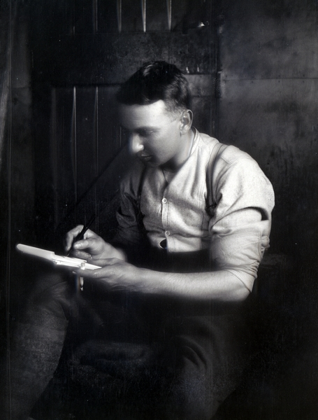 A soldier writing a letter inside : negative