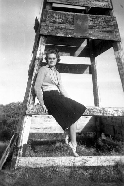 Nan Carroll sitting on a wooden structure : Photograph