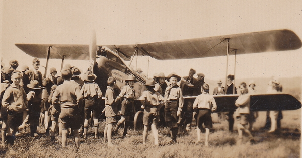 Boy scouts gathered around a bi-plane : Photograph