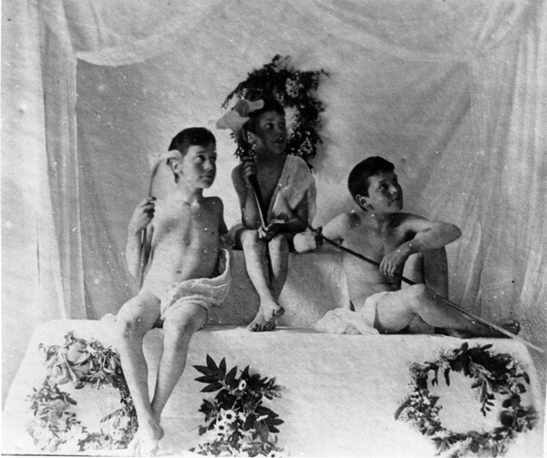Three boys holding white lilies