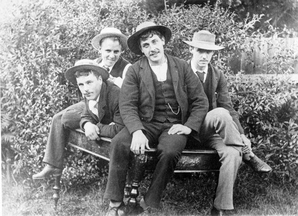 Four young men sitting on a table outside