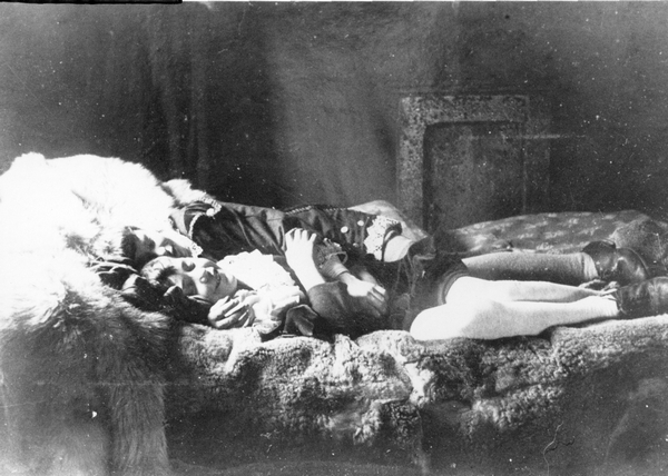 Two children lying on a bed