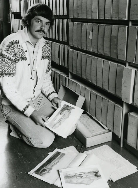 Archivist, Grant Pittams, examines watercolours in the Internal Affairs Department's papers (1979)