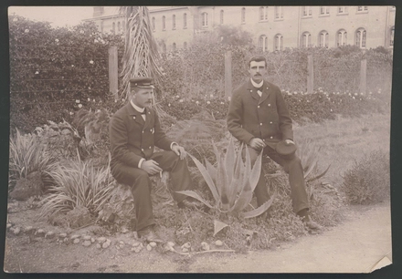 [Two guards sitting on tree stumps smoking, Avondale Lunatic Asylum]