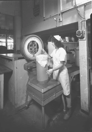 [Woman weighing canister]