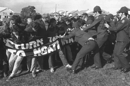 Protestors enveloped in banner 'Return Takaparawhā to Ngāti Whātua Bastion Point Not For Sale' resisting police