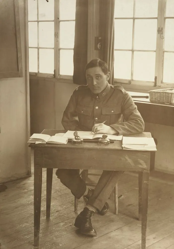 Unidentified WWI soldier, right arm amputated, seated at a desk at Oatlands Park, Surrey, England
