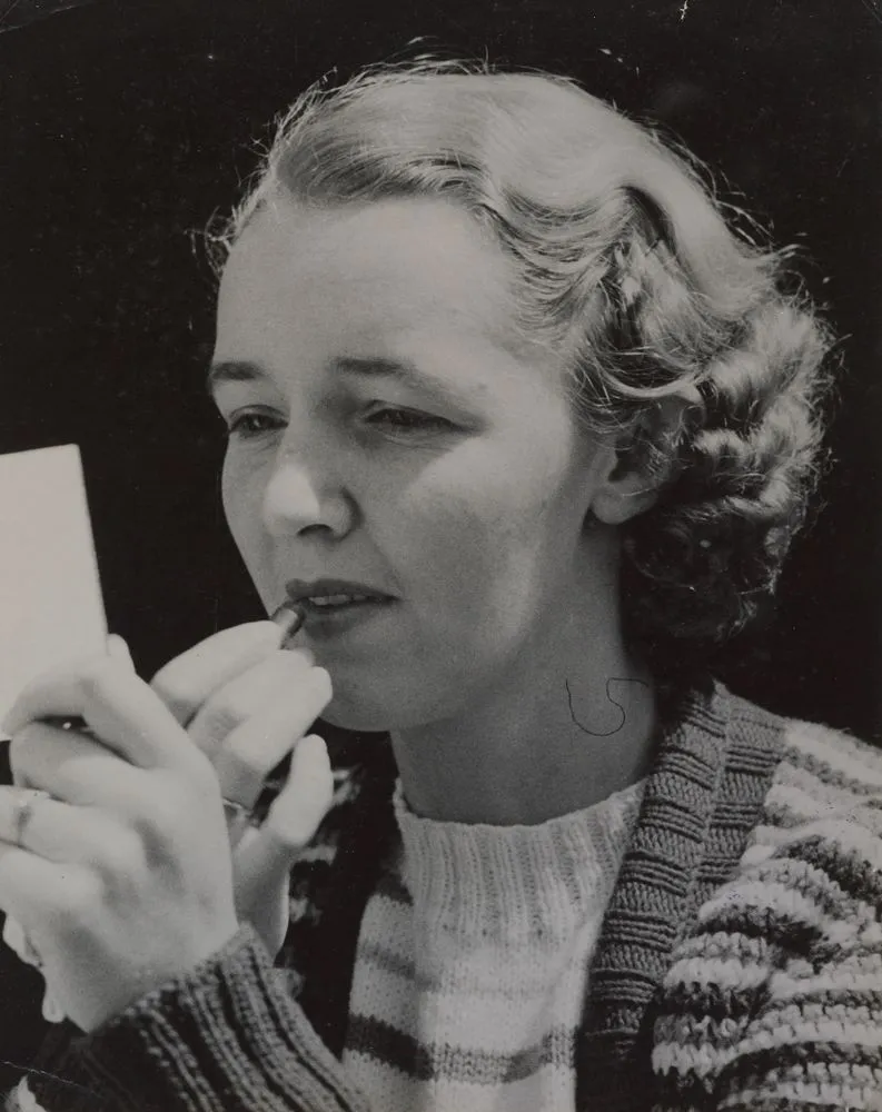 Portrait of a young woman applying lipstick