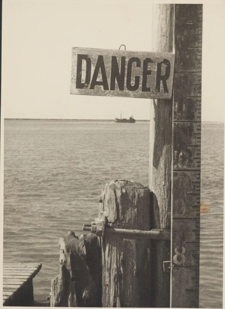 Water height warning sign on pier, England