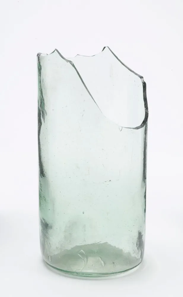 Broken bottom of transparent greenish glass bottle