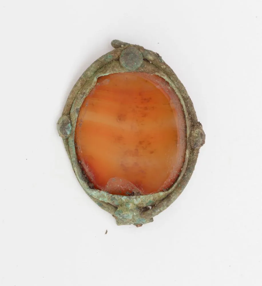 Oval metal and opaque amber brooch
