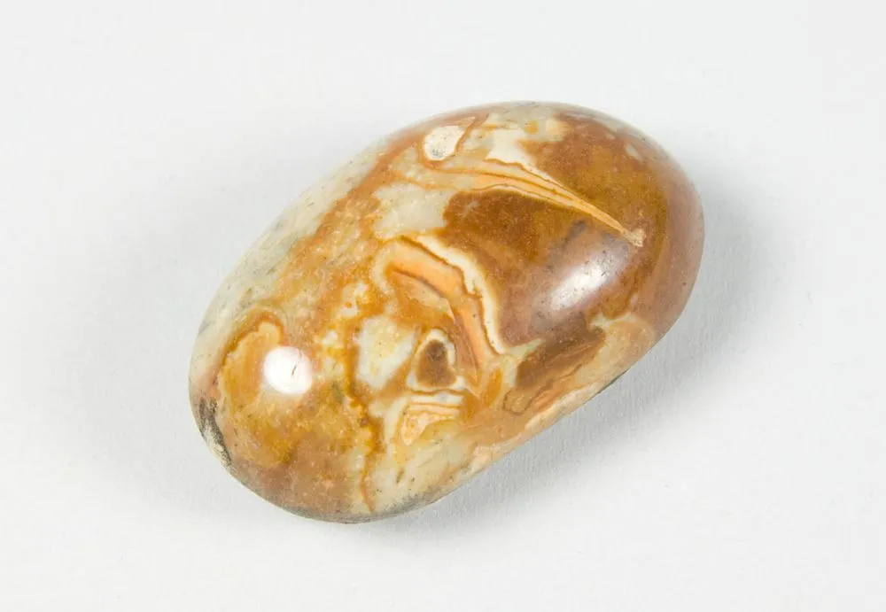 Small polished orange pebble (petrified wood).