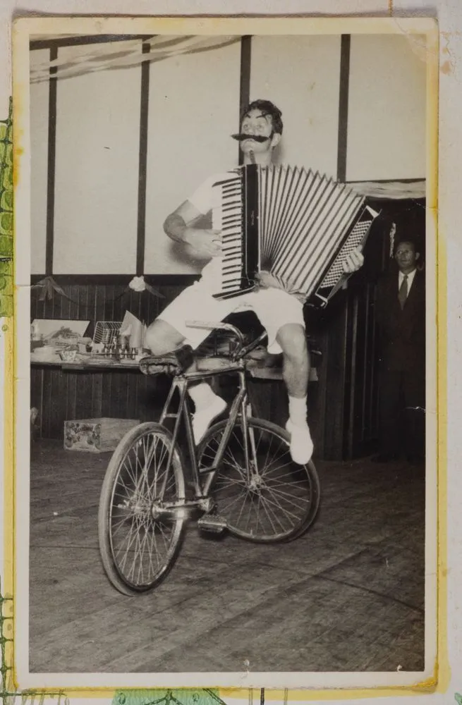 [Clown playing an accordion on a bike]