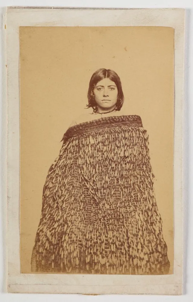 Maori woman wearing long piupiu cloak