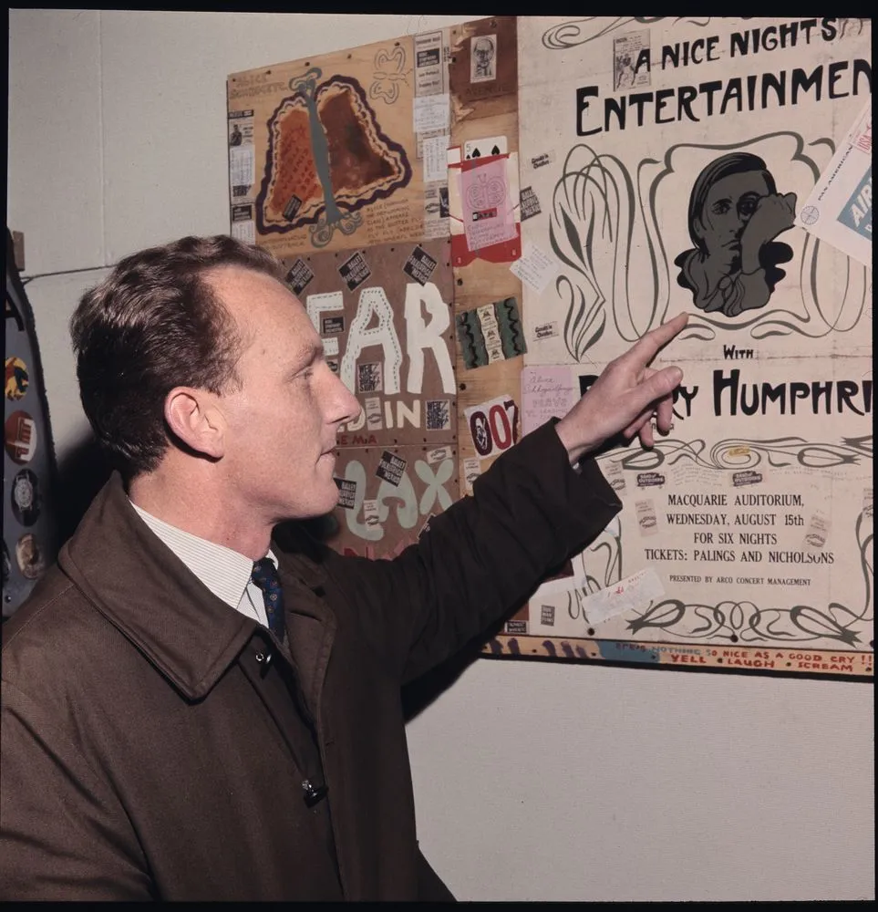 Ross Crothall pointing to one of his art works at his exhibition