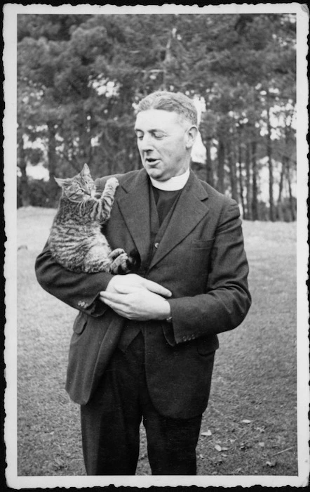 Gordon McKenzie, honorary chaplain to the Royal New Zealand Navy, with cat at HMNZS Tamaki