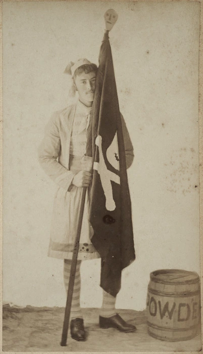 Young man dressed as a pirate holding a black flag