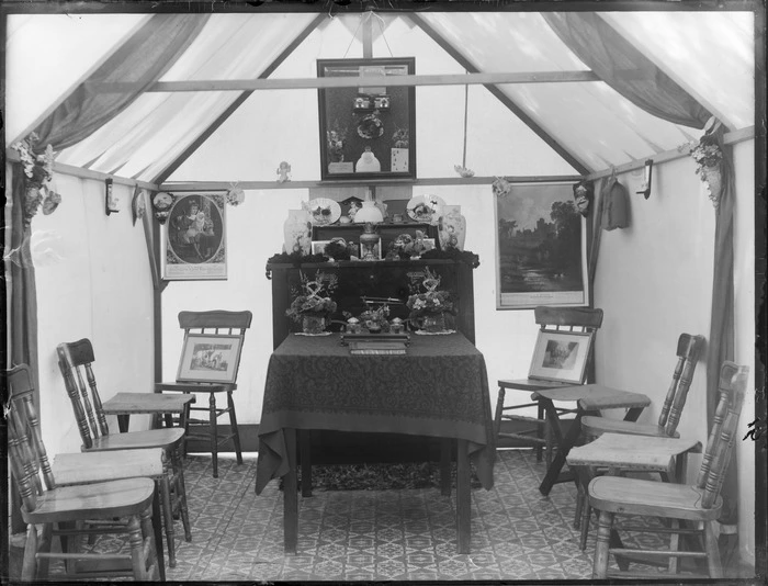 Interior view of a tent, furnished with a cabinet, and chairs, and decorated with prints, mirror, and other ornaments, probably Christchurch district
