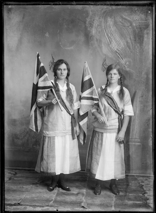 Two unidentified women dressed in identical costumes with Union Jacks in their hands and hair, probably Hastings district