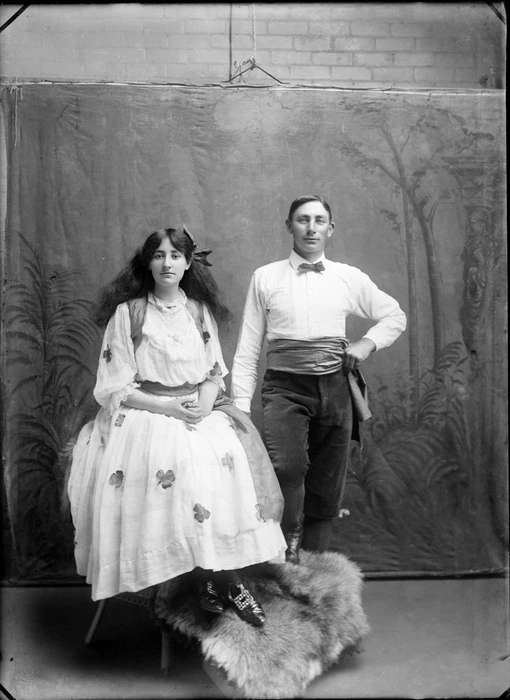 Portrait of unidentified man and woman in dance costume, with painted studio backdrop, probably Christchurch district