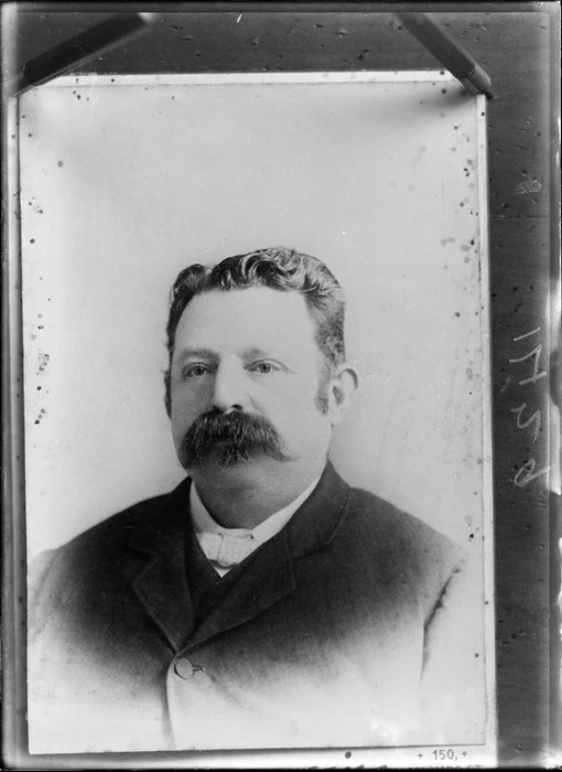 Studio upper torso portrait of unidentified man with sideburns, a large moustache and a polka dot bow tie, Christchurch