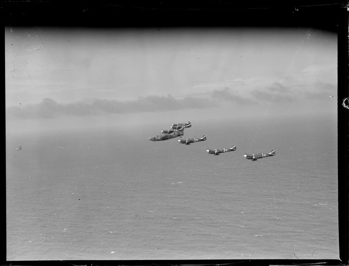 Group of Curtiss P-40 Kittyhawk aircraft flying in formation over ocean