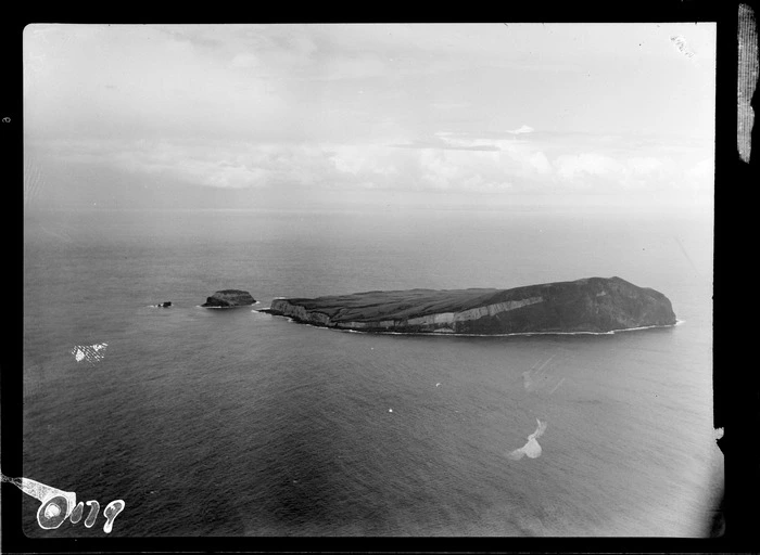 View of Macauley Island, a relatively flat volcanic island with steep beach cliff faces, with Hazard Island beyond, the Kermadec Islands group