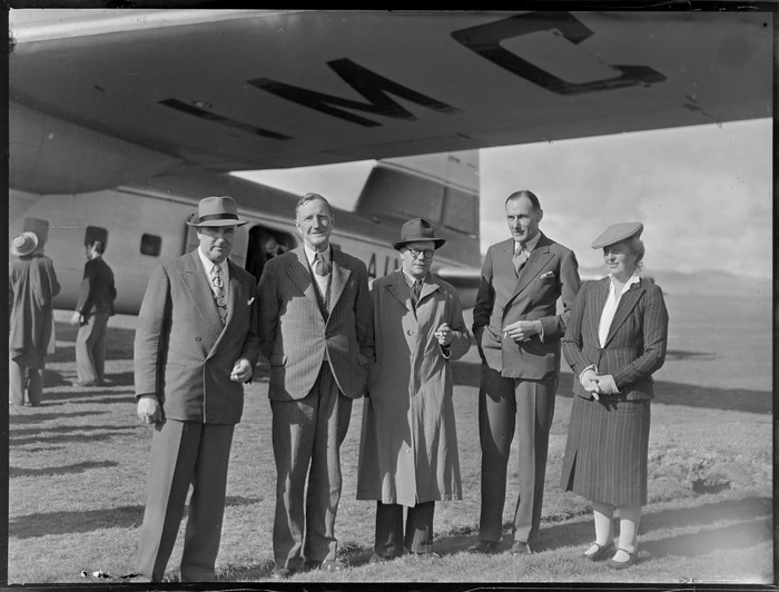 Unidentified group of men, including a woman, standing by a Bristol Freighter aircraft, Kaikohe