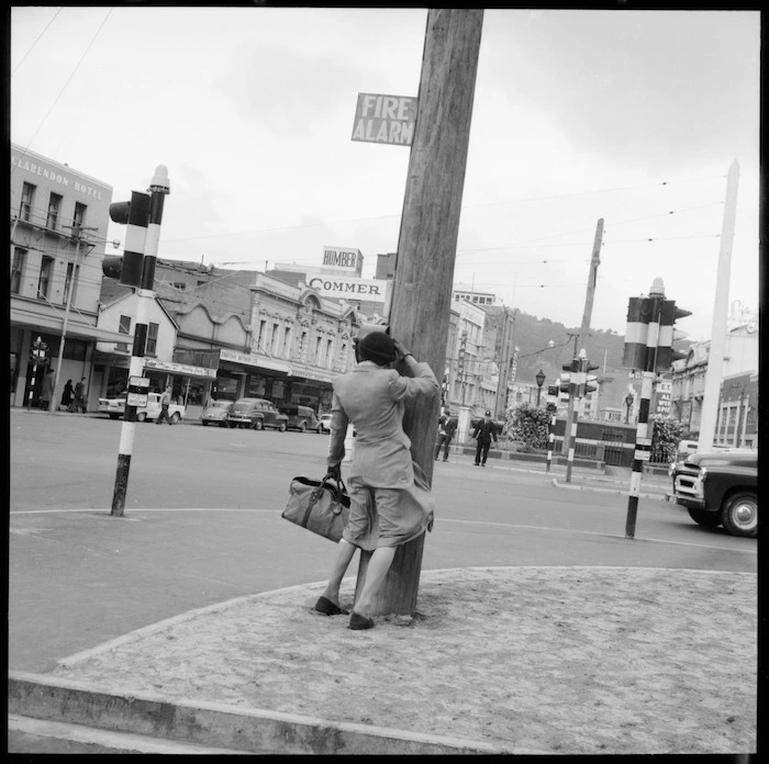 Woman blown against lamp post, Wellington